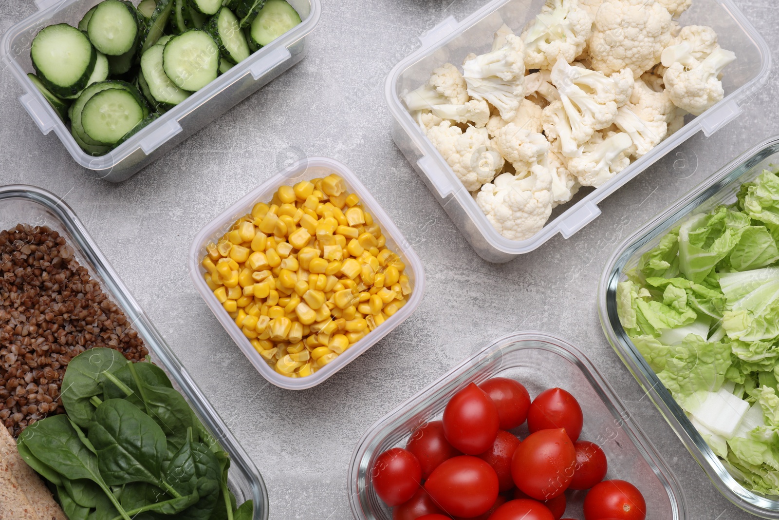 Photo of Glass and plastic containers with different fresh products on light grey table, flat lay