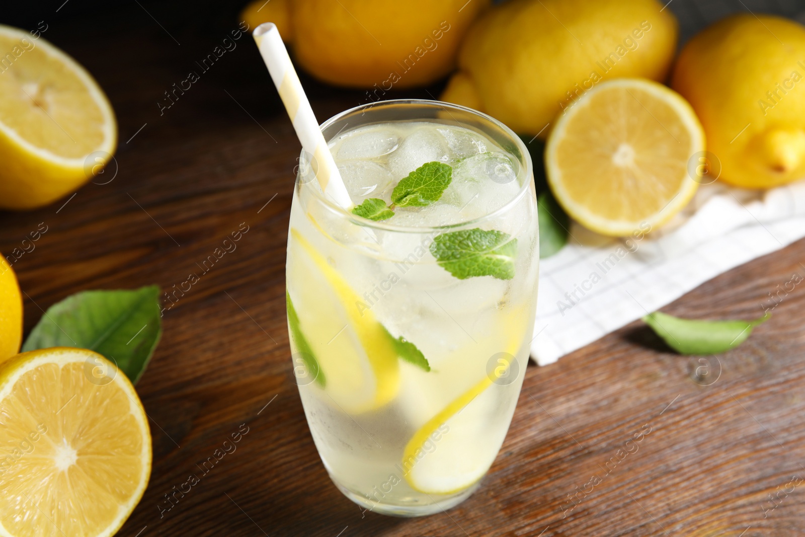 Photo of Cool freshly made lemonade in glass on wooden table, closeup