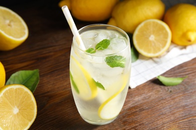 Cool freshly made lemonade in glass on wooden table, closeup