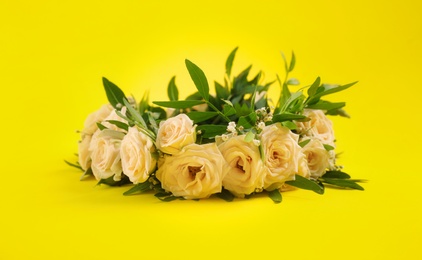 Photo of Wreath made of beautiful flowers on yellow background