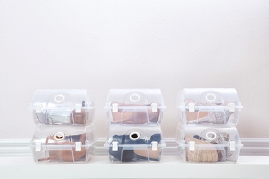 Photo of Shoes in plastic boxes near light wall. Storage organization