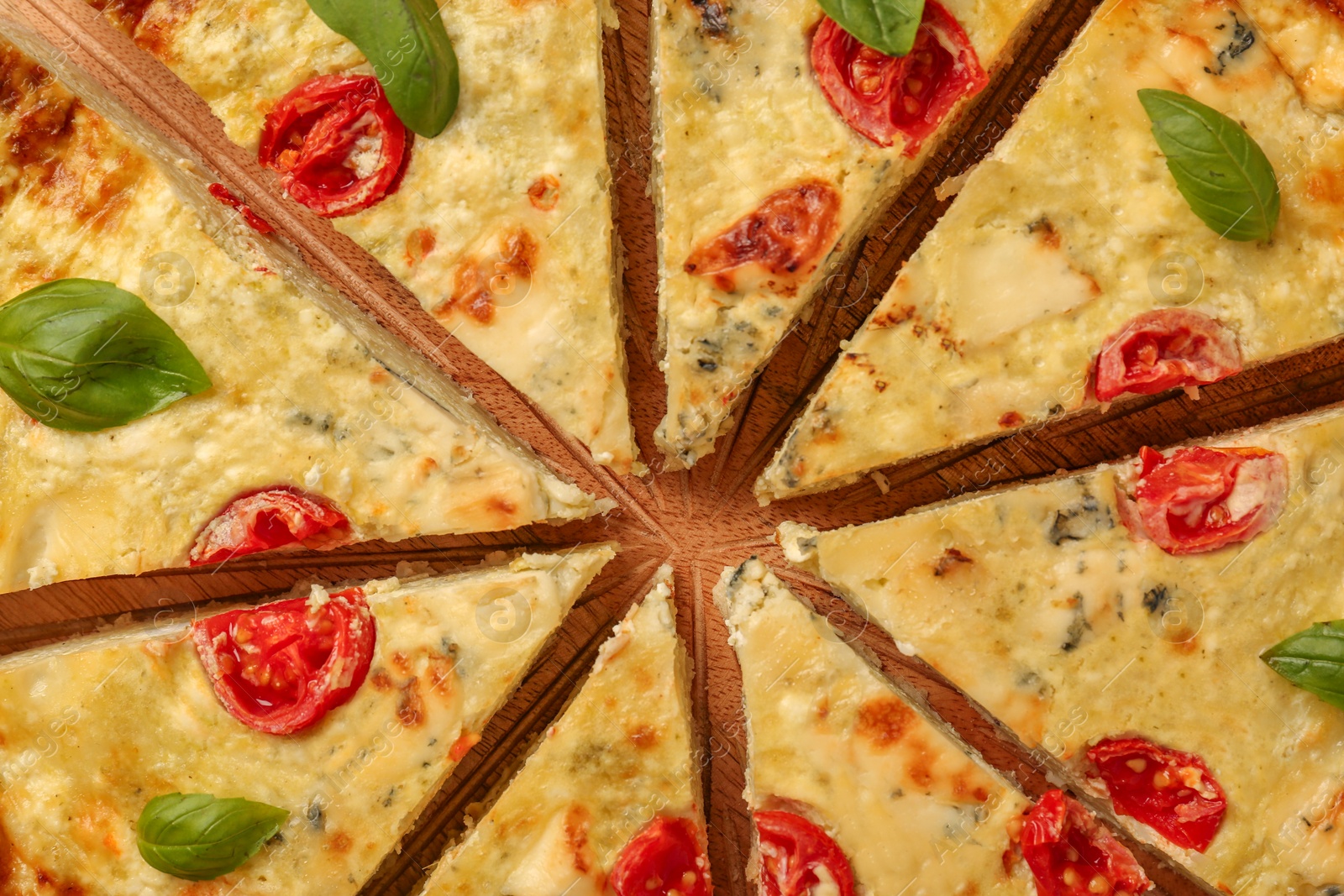 Photo of Delicious homemade cheese quiche on board, top view