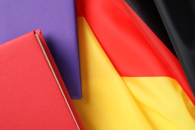 Learning foreign language. Different books on flag of Germany, top view with space for text