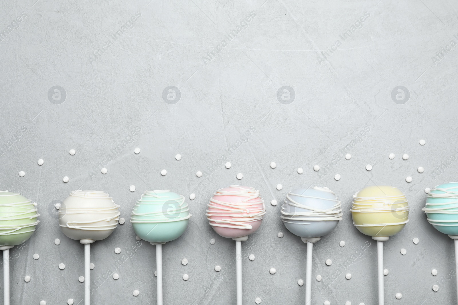 Photo of Sweet cake pops on light grey background, flat lay. Space for text