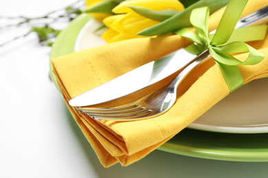 Photo of Festive Easter table setting with floral decor on white background, closeup