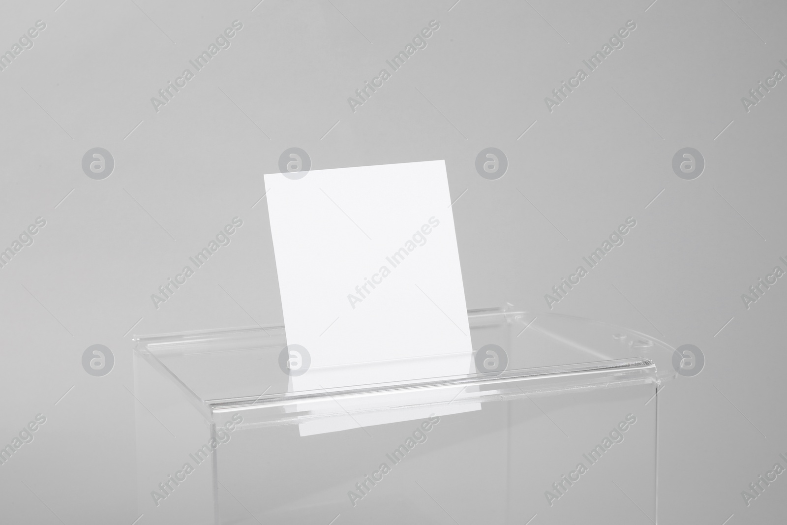 Photo of Ballot box with vote on light grey background, closeup. Election time