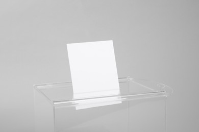 Photo of Ballot box with vote on light grey background, closeup. Election time