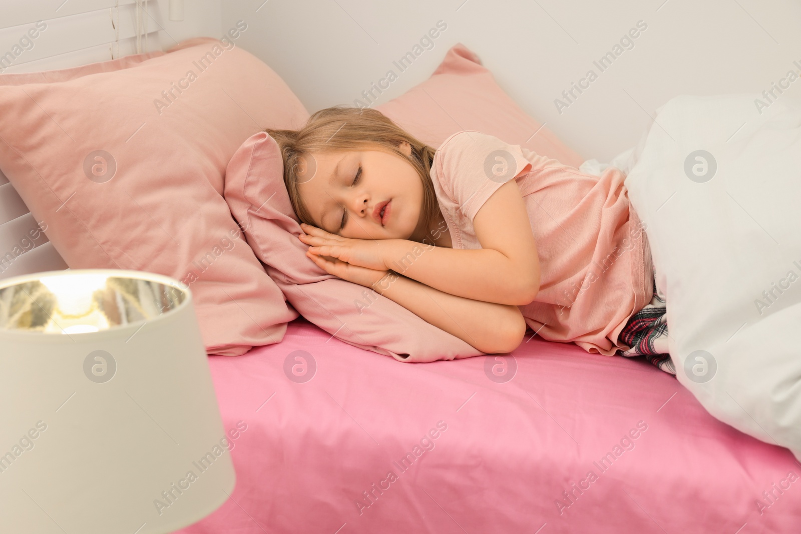 Photo of Little girl snoring while sleeping in bed at home