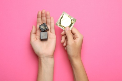 Photo of Woman with sex dice and condom on pink background, top view