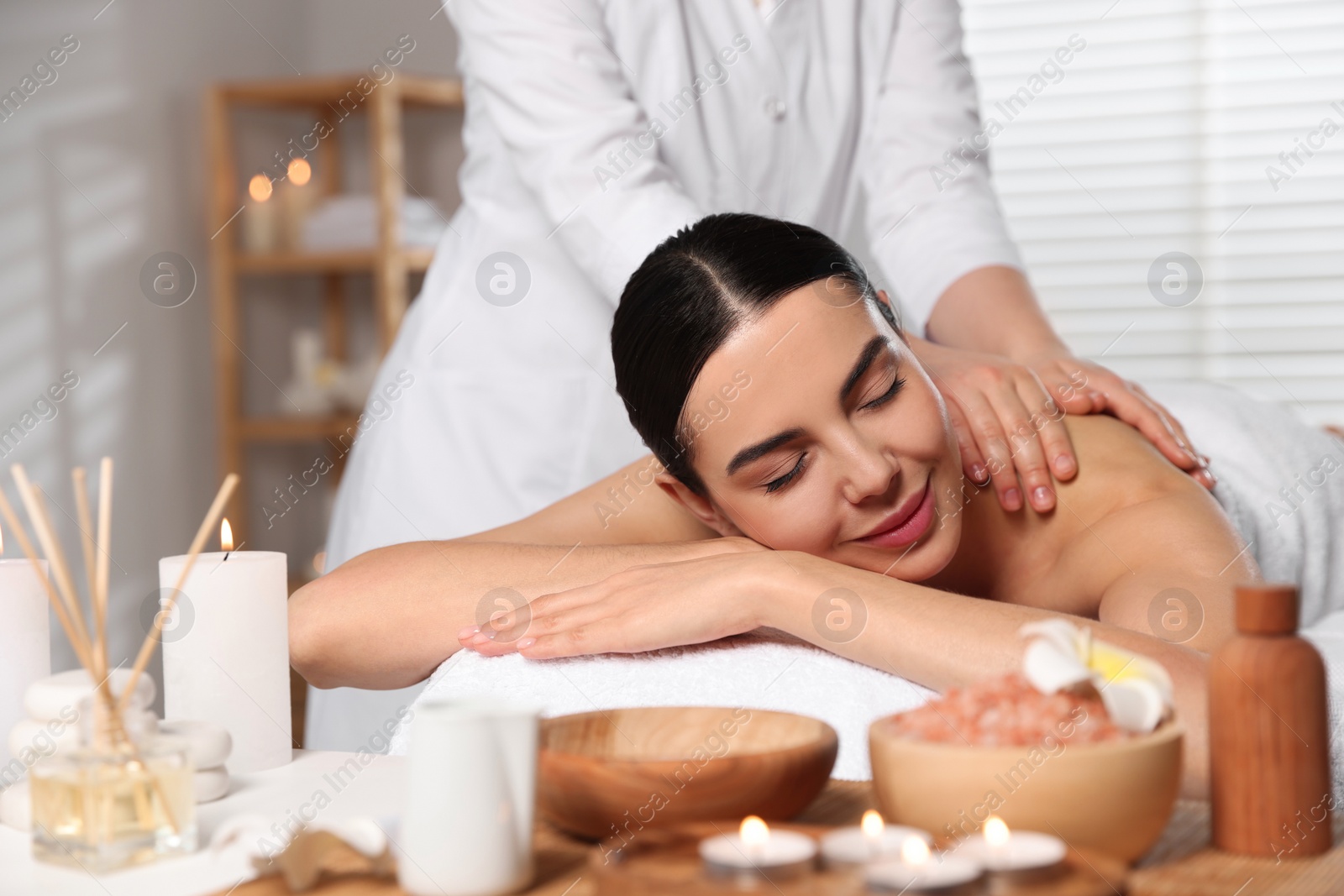 Photo of Beautiful woman receiving back massage in beauty salon, closeup