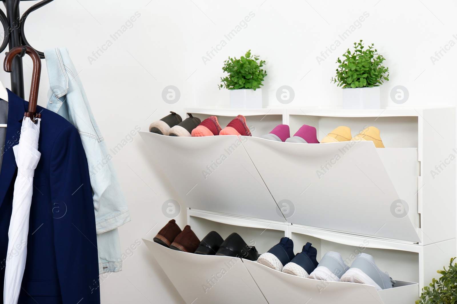 Photo of Shoe cabinet with footwear in room. Storage ideas