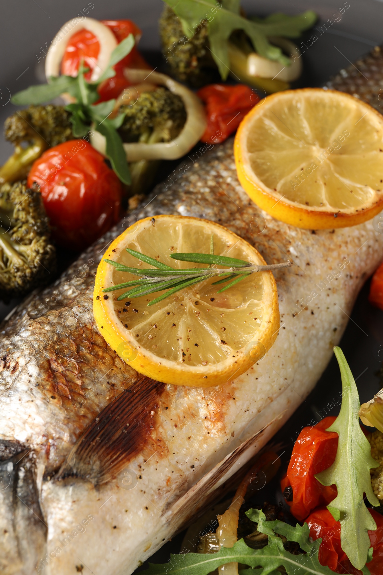 Photo of Baked fish with vegetables, rosemary and lemon, closeup