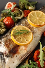 Baked fish with vegetables, rosemary and lemon, closeup