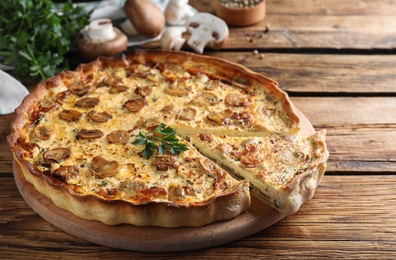 Photo of Delicious pie with mushrooms and cheese on brown wooden table