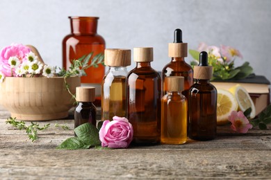 Photo of Aromatherapy. Different essential oils and flowers on wooden table