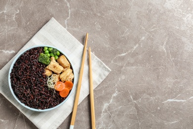 Photo of Plate of boiled brown rice with meat served on table, top view. Space for text