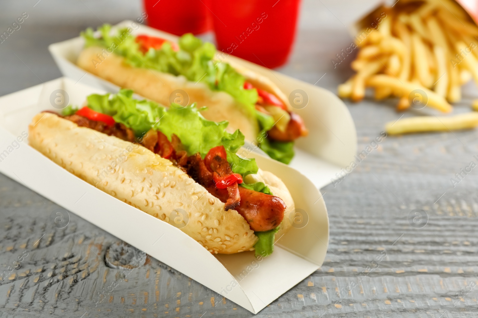 Photo of Hot dogs on grey wooden table. Fast food