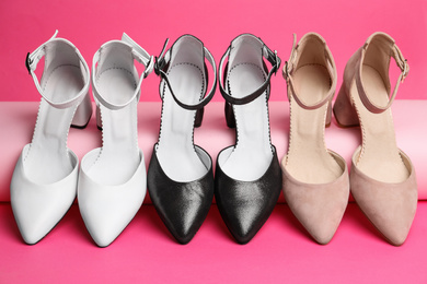 Photo of Many stylish female shoes on pink background