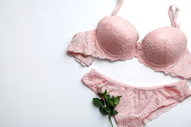 Photo of Elegant women's underwear and rose flower on white background, flat lay