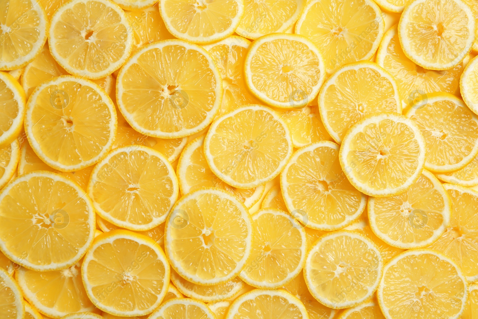 Photo of Slices of fresh juicy lemons as background, top view