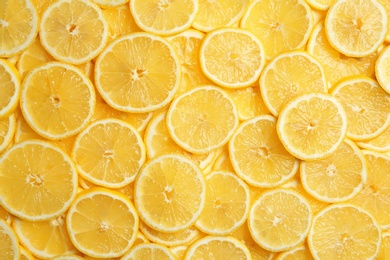 Photo of Slices of fresh juicy lemons as background, top view