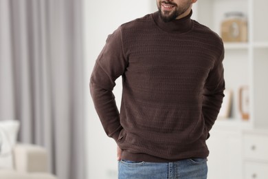 Man in stylish sweater at home, closeup. Space for text
