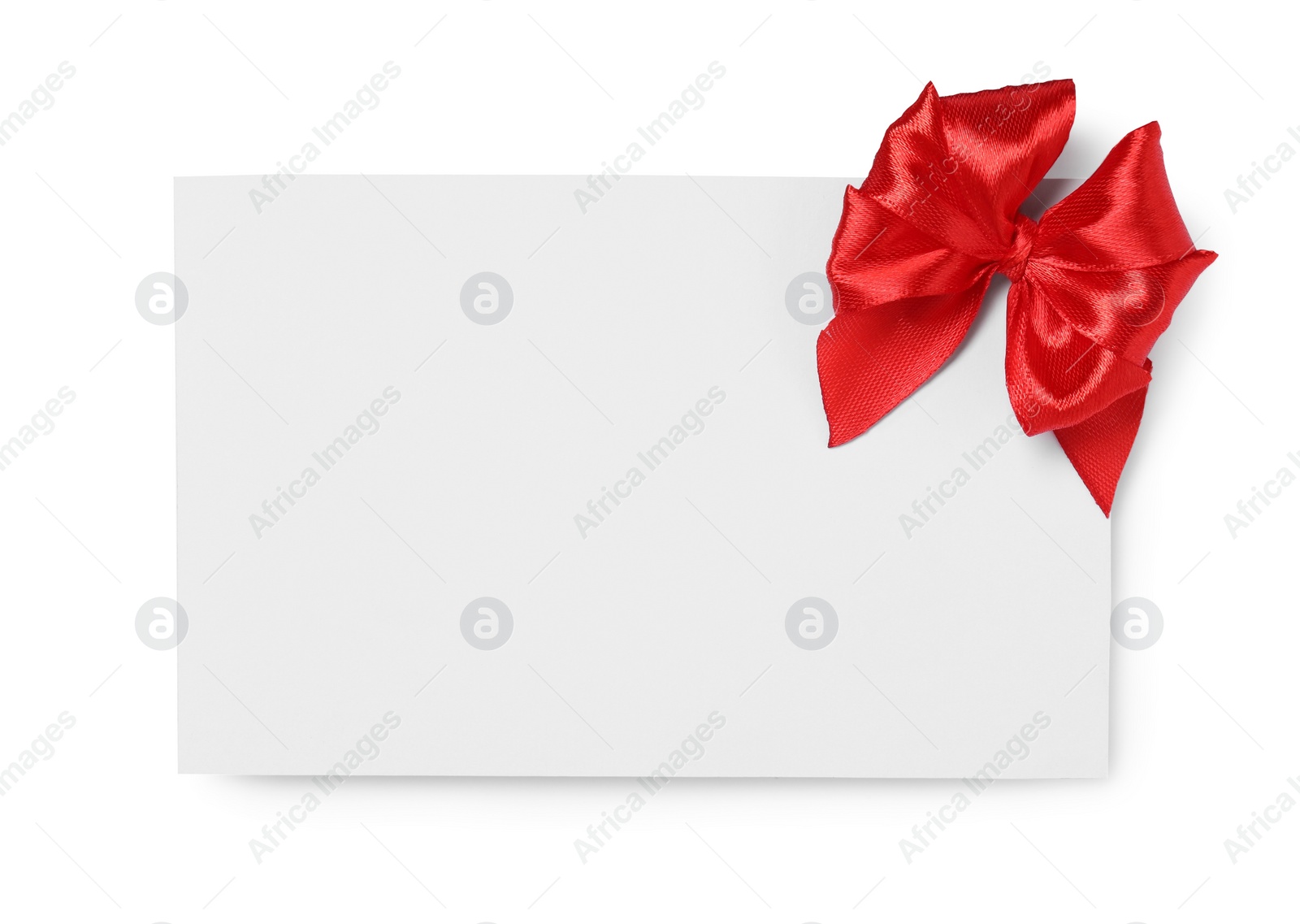 Photo of Blank gift card with red bow isolated on white, top view