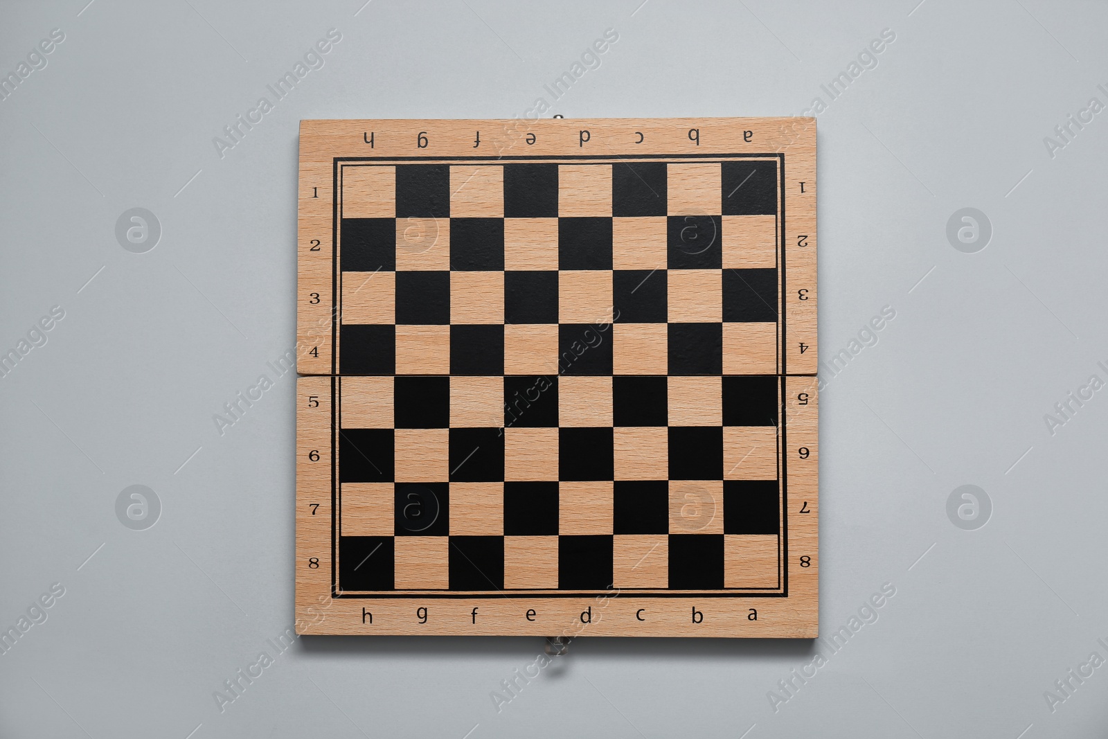 Photo of Empty wooden checkerboard on light grey background, top view