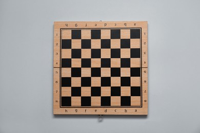 Photo of Empty wooden checkerboard on light grey background, top view