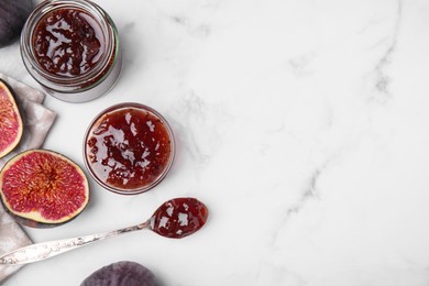 Tasty sweet fig jam and fruits on white marble table, flat lay. Space for text