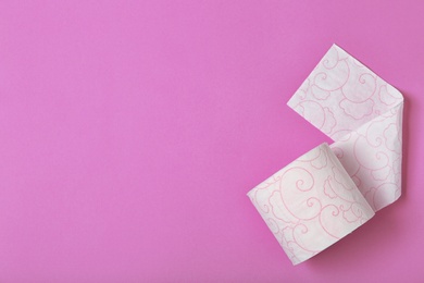 Photo of Roll of toilet paper on color background, top view. Space for text