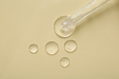 Photo of Pipette with samples of cosmetic serum on beige background, flat lay