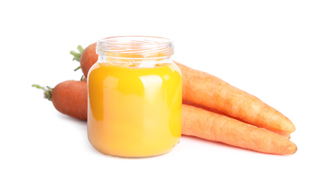 Jar with baby food and fresh carrots on white background