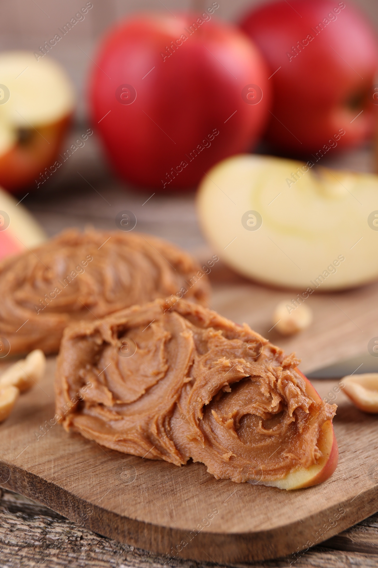 Photo of Pieces of fresh apple with peanut butter on table