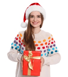 Photo of Happy young woman in Santa hat and sweater with gift box on white background. Christmas celebration