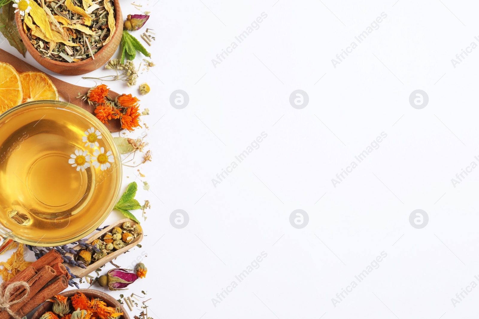 Photo of Freshly brewed tea and dried herbs on white background, top view. Space for text