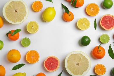 Photo of Frame made of different citrus fruits on white background, flat lay. Space for text