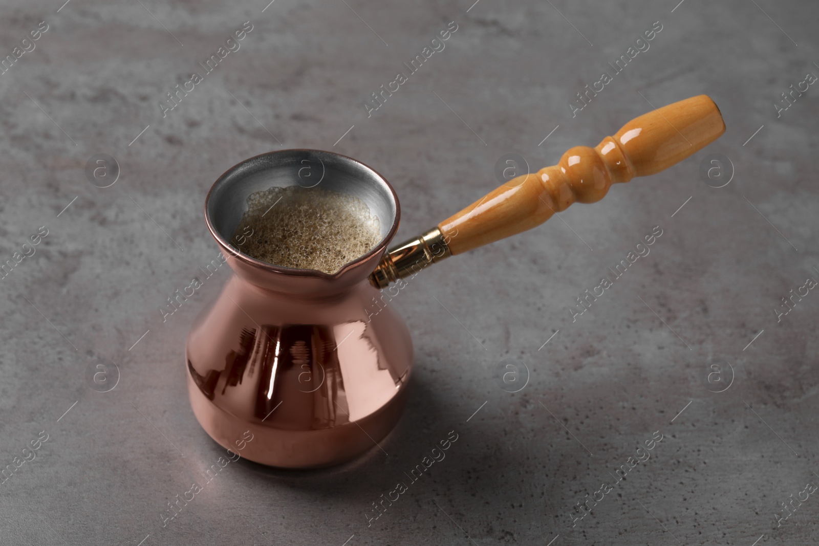 Photo of Cezve with Turkish coffee on grey table