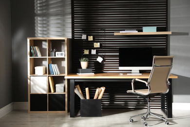 Comfortable workplace with computer and office chair. Stylish room interior