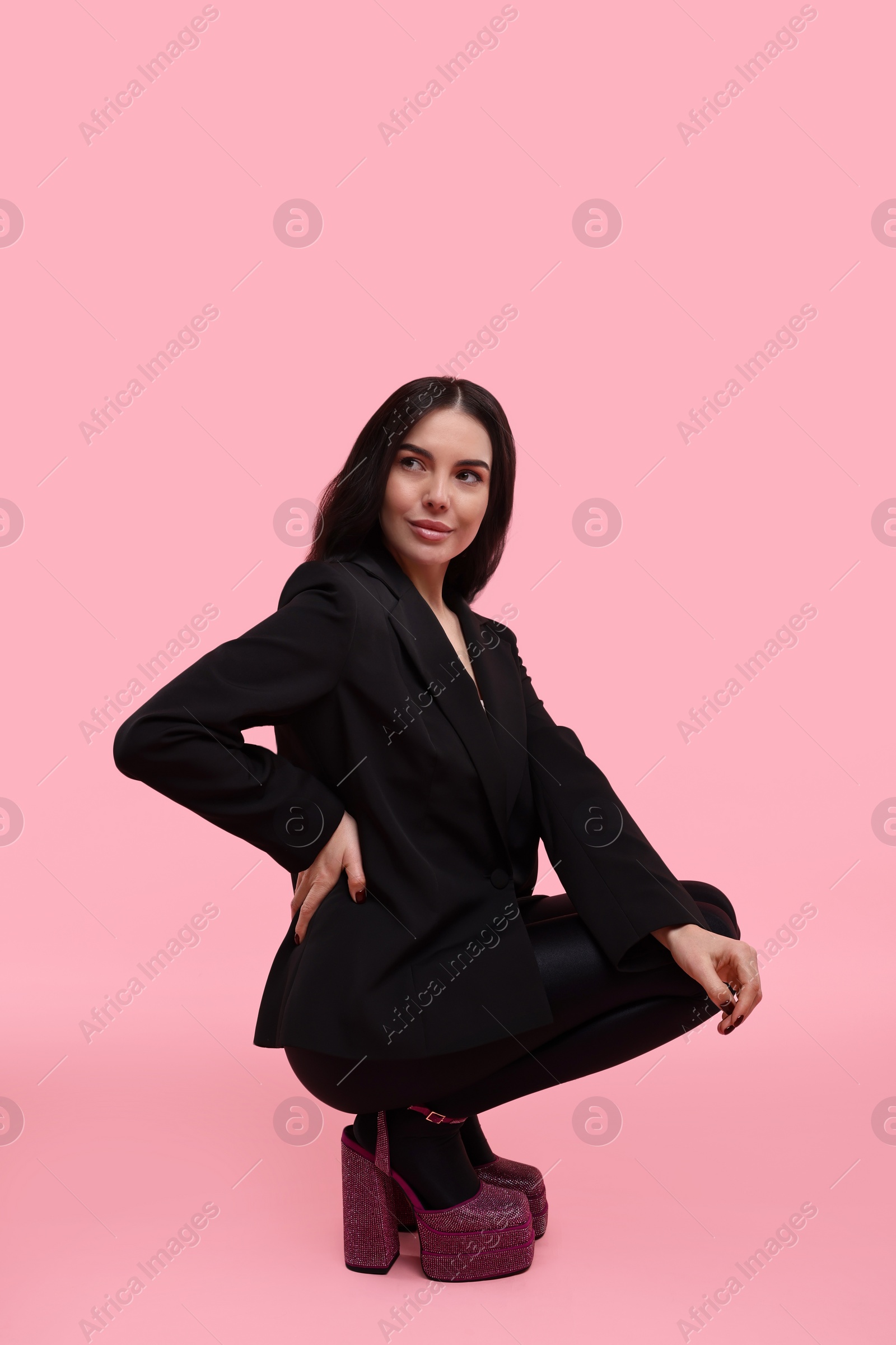 Photo of Stylish woman in black jacket on pink background