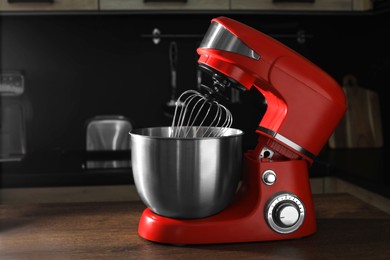 Photo of Modern red stand mixer on wooden table in kitchen