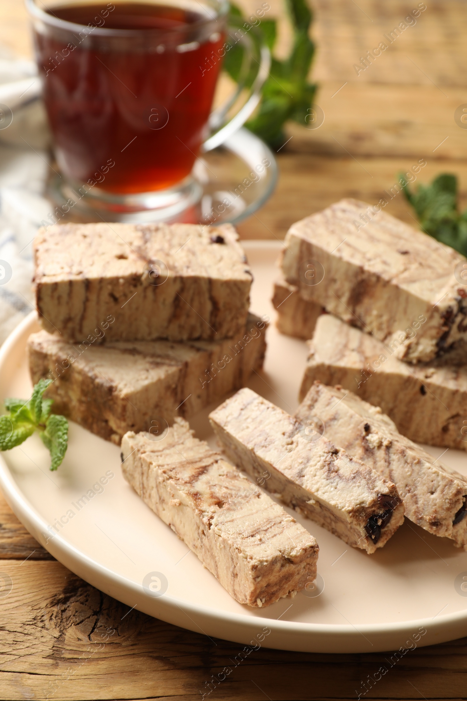 Photo of Tasty chocolate halva with mint on wooden table