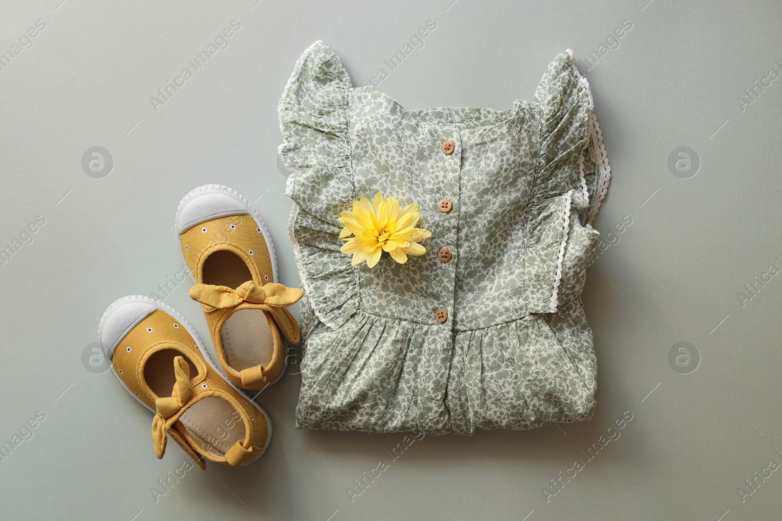 Photo of Stylish child clothes and shoes on grey background, flat lay