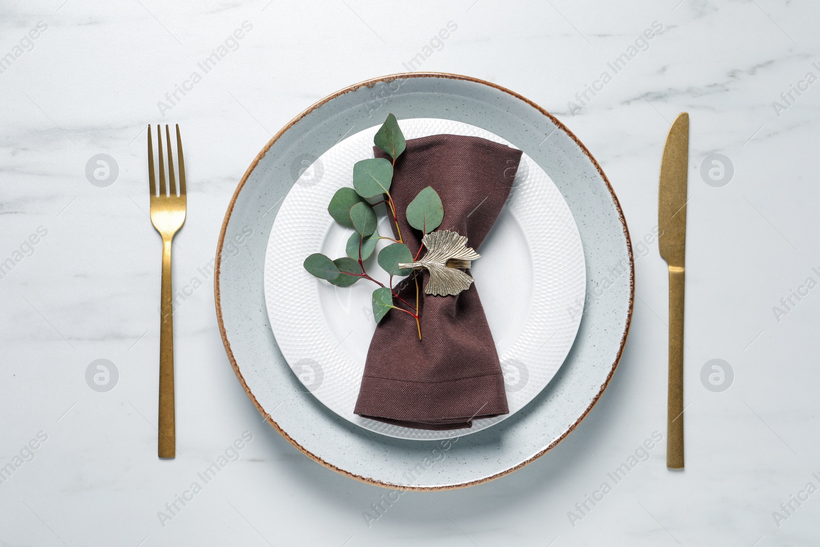 Photo of Stylish table setting with cutlery and eucalyptus leaves, flat lay