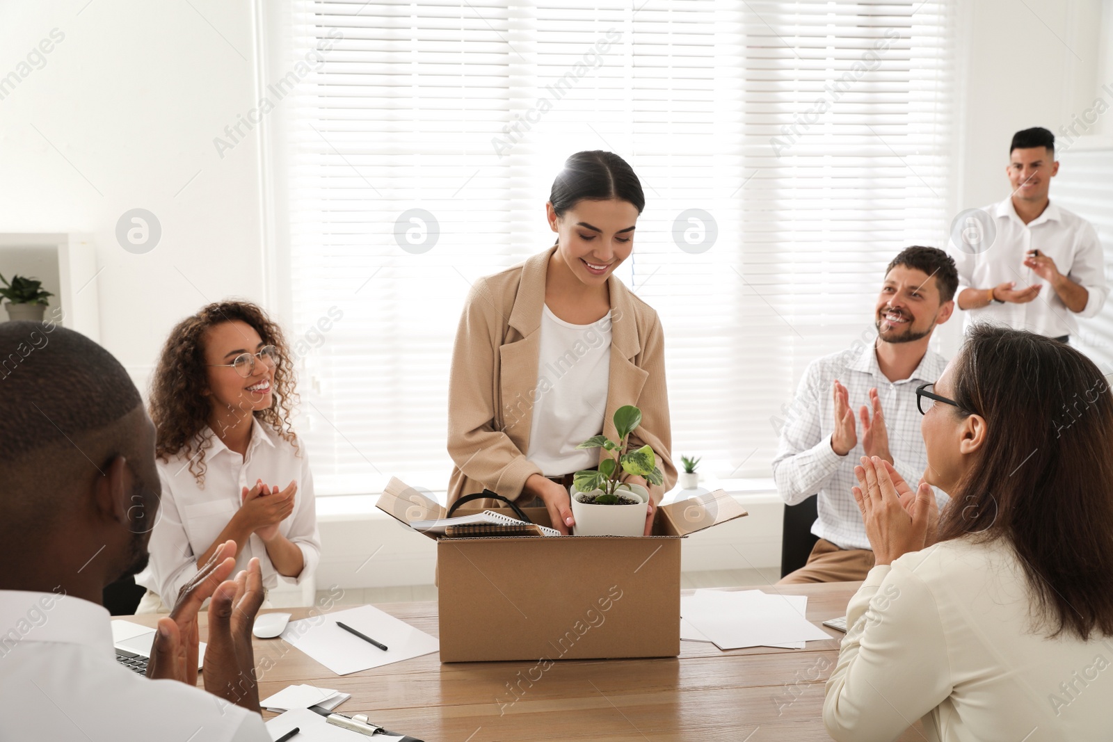 Photo of Group of coworkers welcoming new employee in team indoors