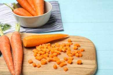 Photo of Board with cut carrot on color background