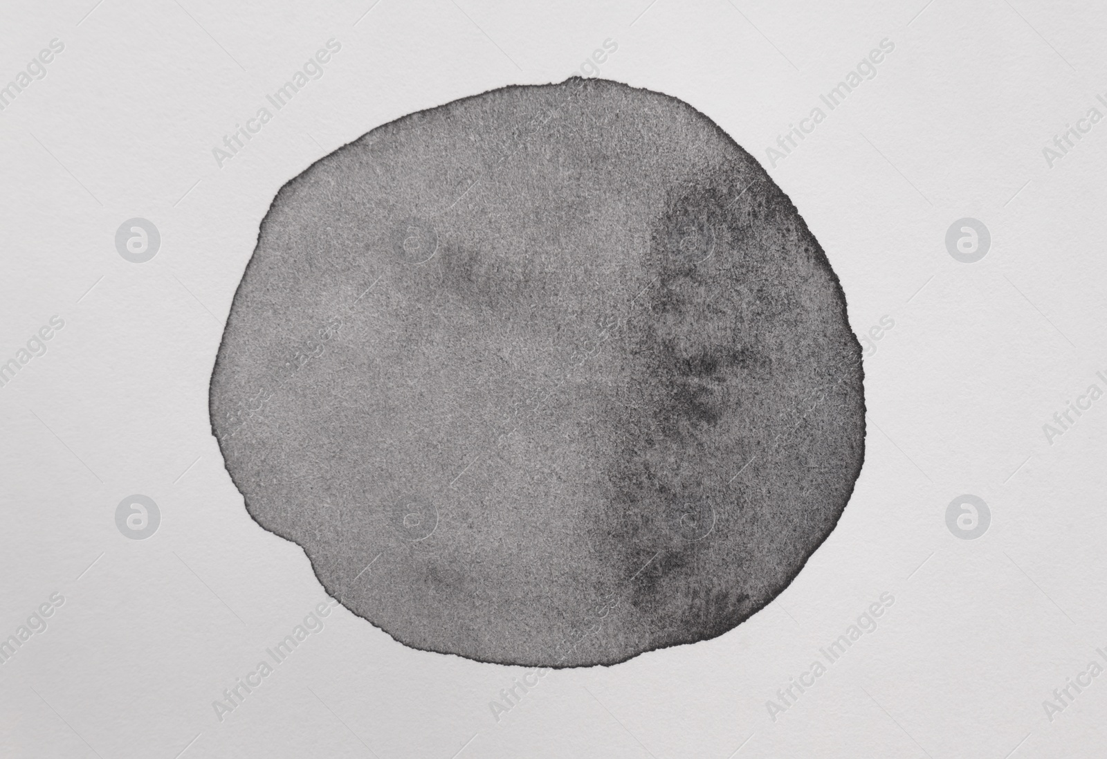 Photo of Black watercolor circle on white canvas, top view