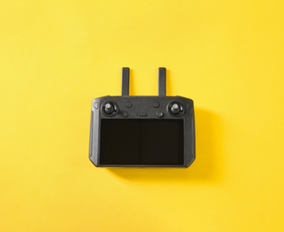 Photo of New modern drone controller on yellow background, top view