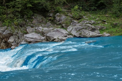 Photo of Mountain river flowing along rocky banks in wilderness