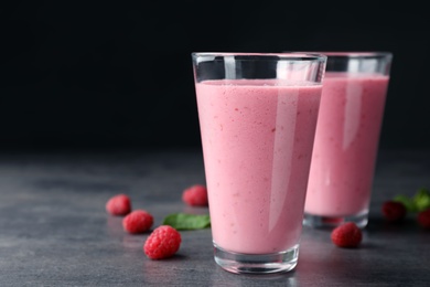 Photo of Delicious smoothie in glasses and fresh raspberries on table